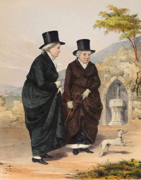 19th-century illustration of two women in dark, formal coats and tall hats walking side by side on a path. One gestures as if speaking. A small dog stands nearby, and a rural landscape with hills and a stone structure appears behind them.