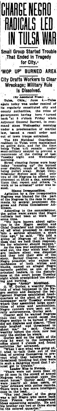 This historical newspaper clipping, titled "CHARGE NEGRO RADICALS LED IN TULSA WAR," presents a biased perspective on the 1921 Tulsa Race Massacre, blaming Black residents for the violence. The article describes efforts to clear the burned district, the lifting of military rule, and the city's response to the destruction.